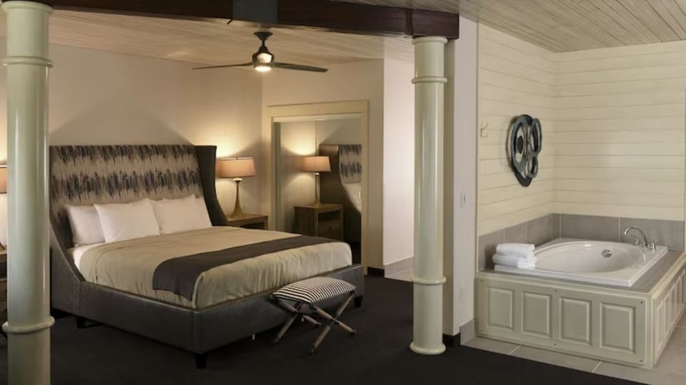 Indulge in a luxe suite with bed and private soaking tub.