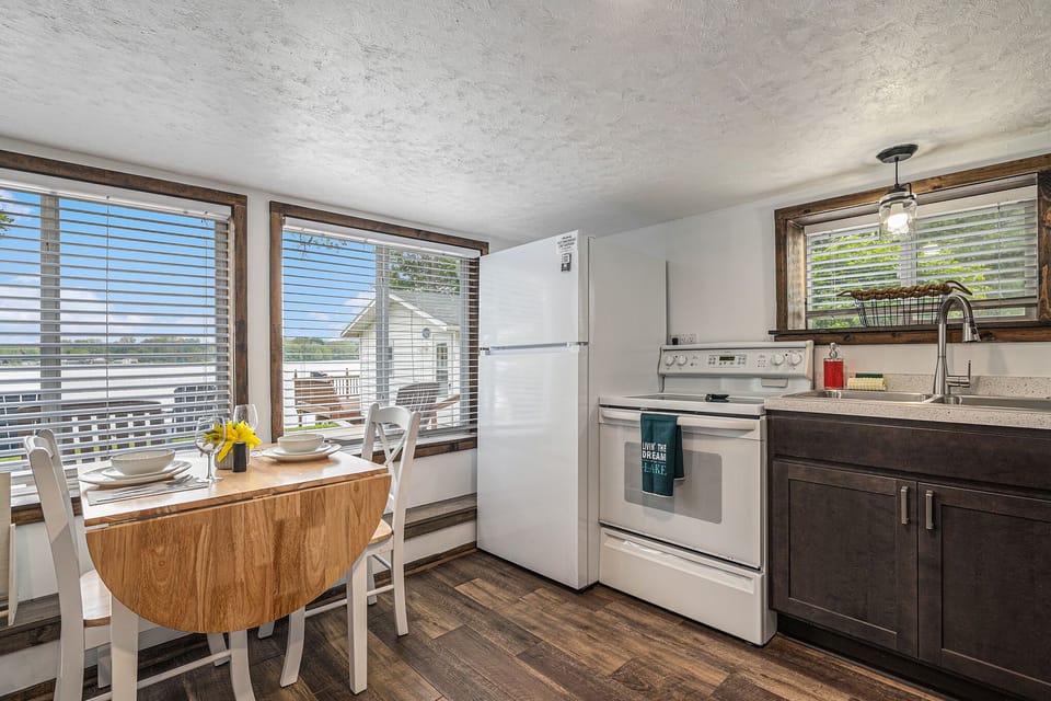 Kitchen, dining room table, electric stove and refrigerator