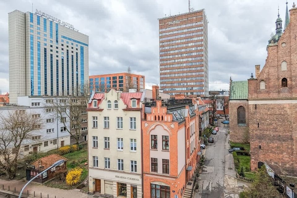 Urban city view with modern high-rise buildings and red-brick rooftops in the old town.