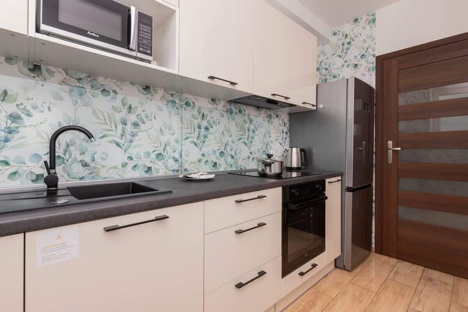Fully equipped kitchen with upper and lower cabinetry, backsplash and dining area.