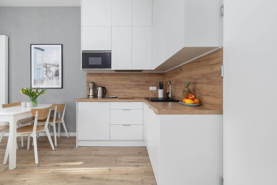 Bright open-plan living room with a grey sofa and a modern kitchenette.