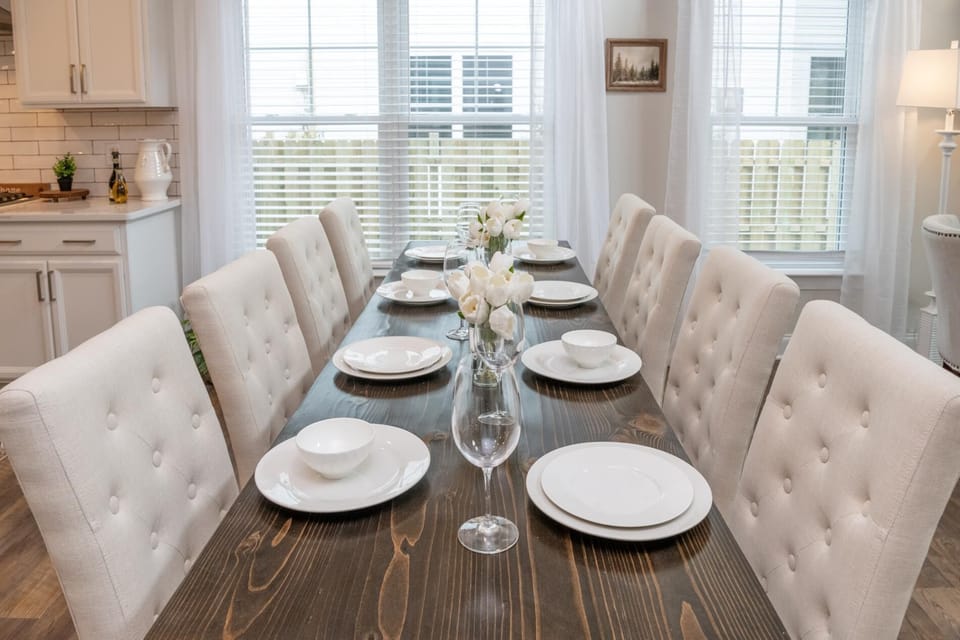 Stunning upholstered high-back chairs surround a rustic wood dining table.