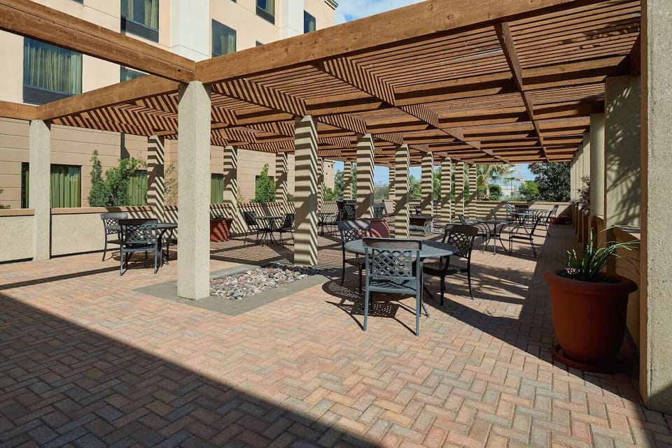 Relax outdoors beneath the pergola with shaded lounge seating.