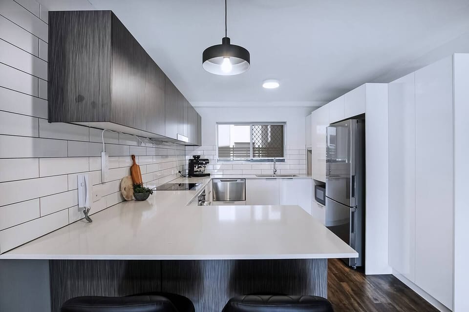 The modern kitchen comes fully equipped to prepare meals at home with sleek appliances and cooking utensils.
