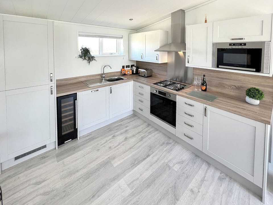 Kitchen with full-size fridge freezer, wine chiller, dishwasher, oven, microwave, and toaster. Fully equipped with crockery and cutlery | St Mabyn Lodge Escape, Bodmin