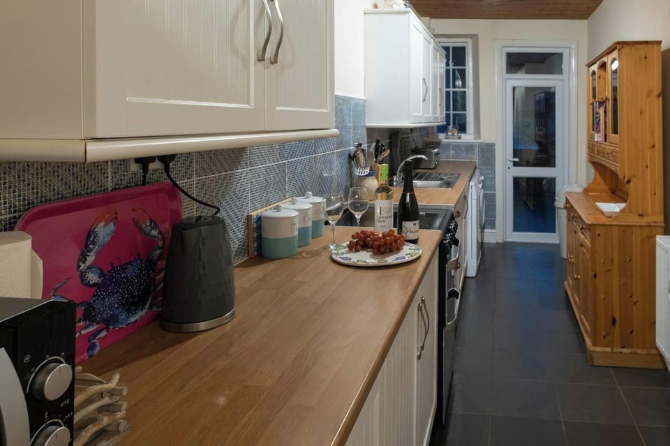 Fitted kitchen, cooker, sink, microwave, kettle, toaster and Welsh dresser