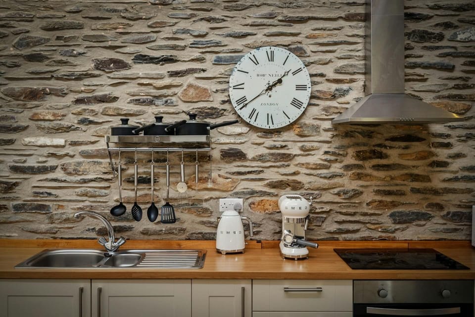 Featured stone wall with Clock in the kitchen, kettle and coffee machine