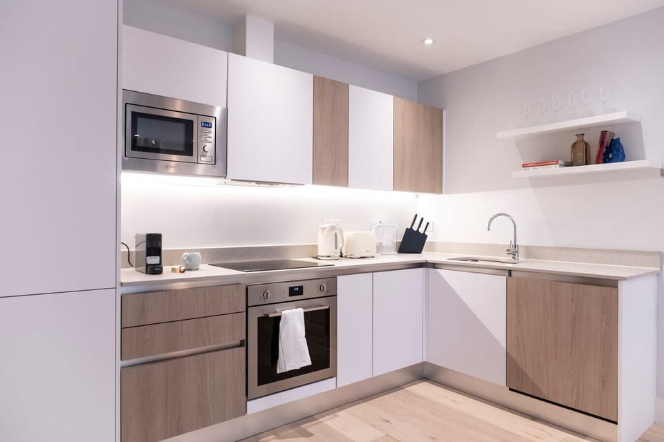 The fully equipped kitchen has an oven and induction hob, microwave, kettle, toaster, dishwasher, Nespresso machine, and a dining table with four chairs.
