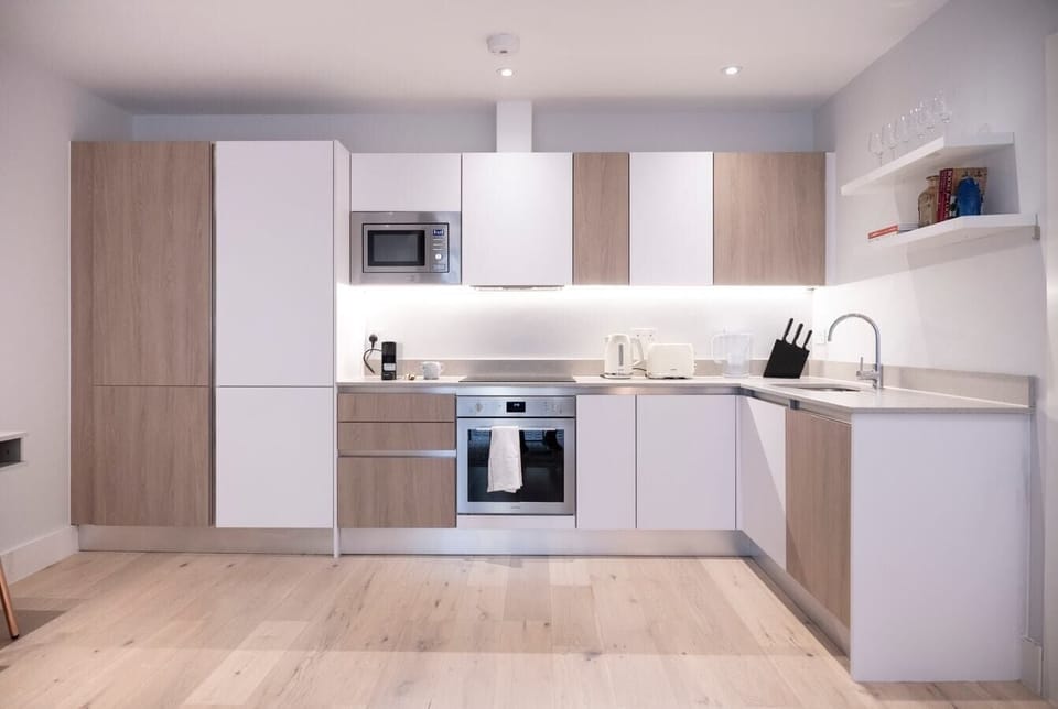 The fully equipped kitchen has an oven and induction hob, microwave, kettle, toaster, dishwasher, Nespresso machine, and a dining table with four chairs.