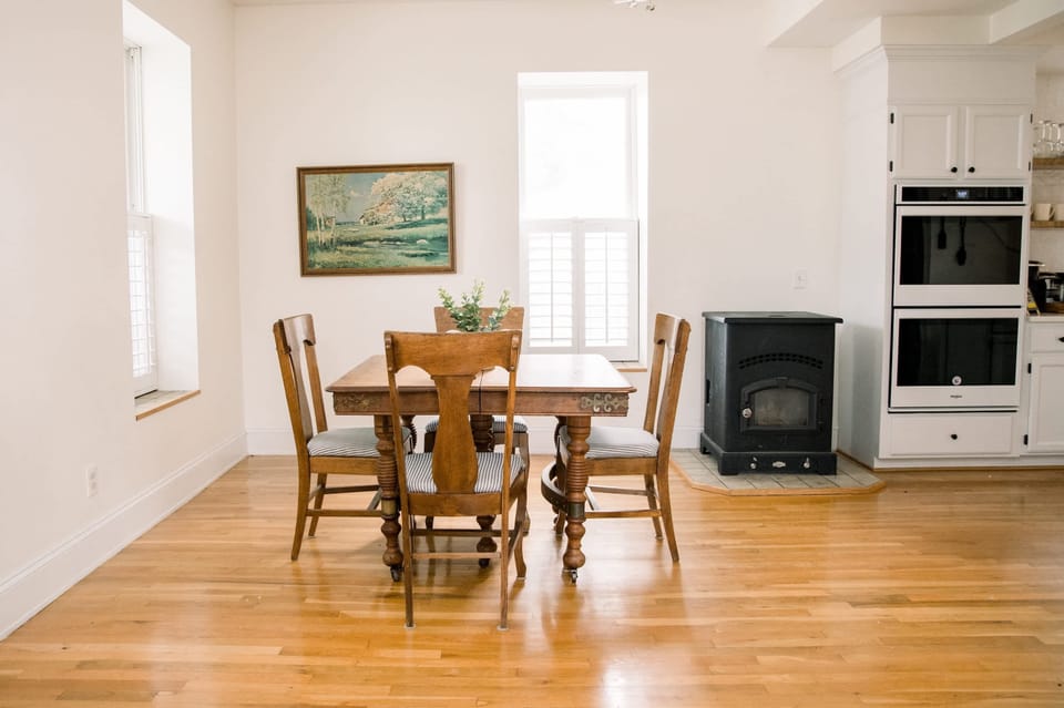 Bright entryway leads to open dining area with warm wood floors, curated decor, and natural light streaming through windows 🌞✨