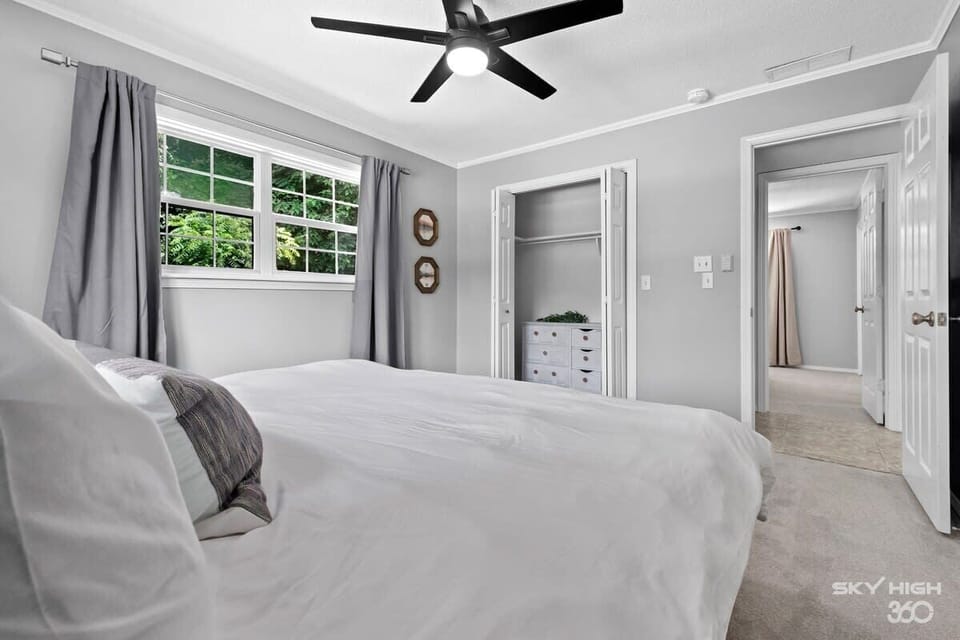 Spacious bedroom with queen bed and ceiling fan—ideal for restful mornings.