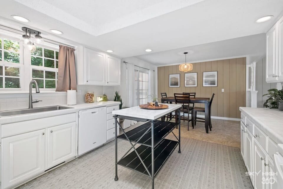 Bright kitchen with dining table for 4 and breakfast bar — perfect for cooking and sharing meals with your group.