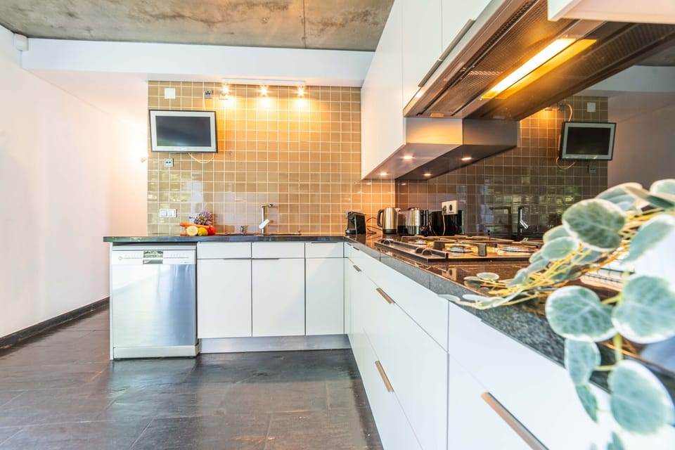 Modern kitchen with orange tile backsplash and island — Villa Jasmine, holiday villa in Herdade de Aroeira