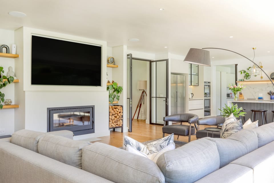 First lounge area with wood fireplace and large wall mounted smart TV.