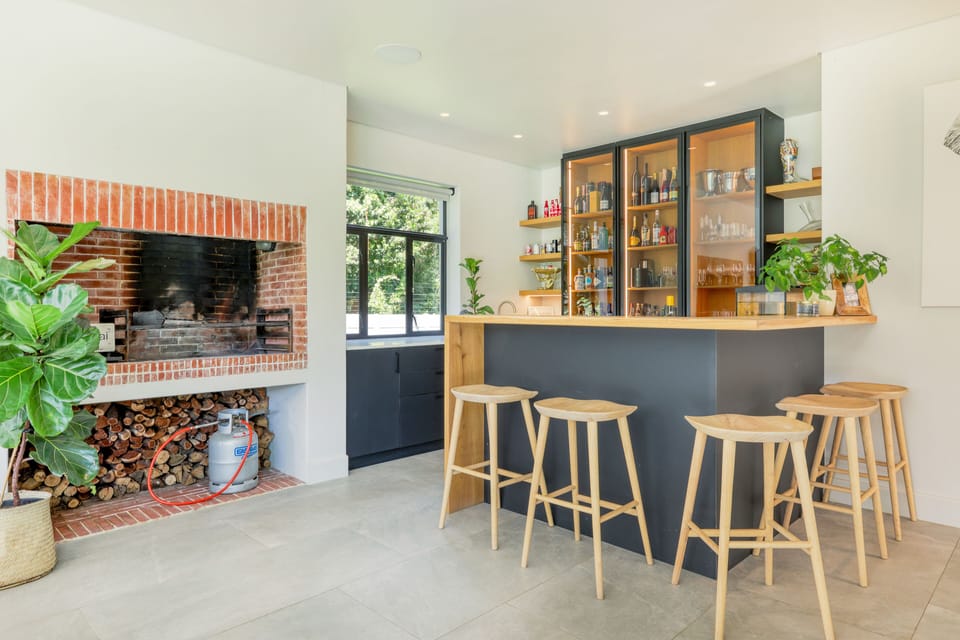 Bar with prep sink, fridge, wood BBQ area and Pizza oven.