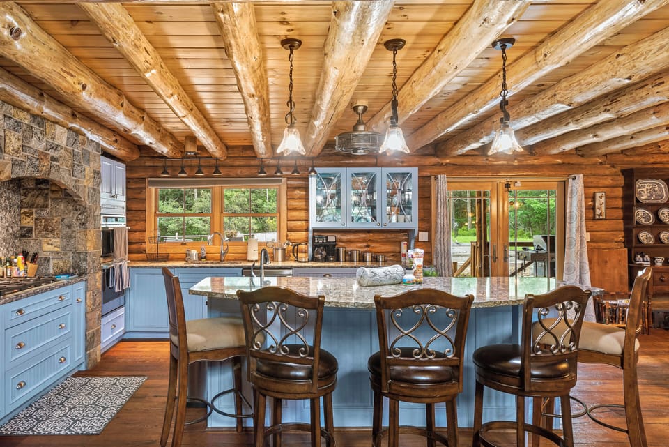 Kitchen features an island with barstool seating.