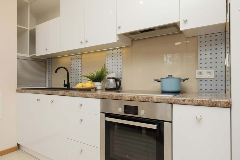 White cabinets with a dining table and fresh flowers.