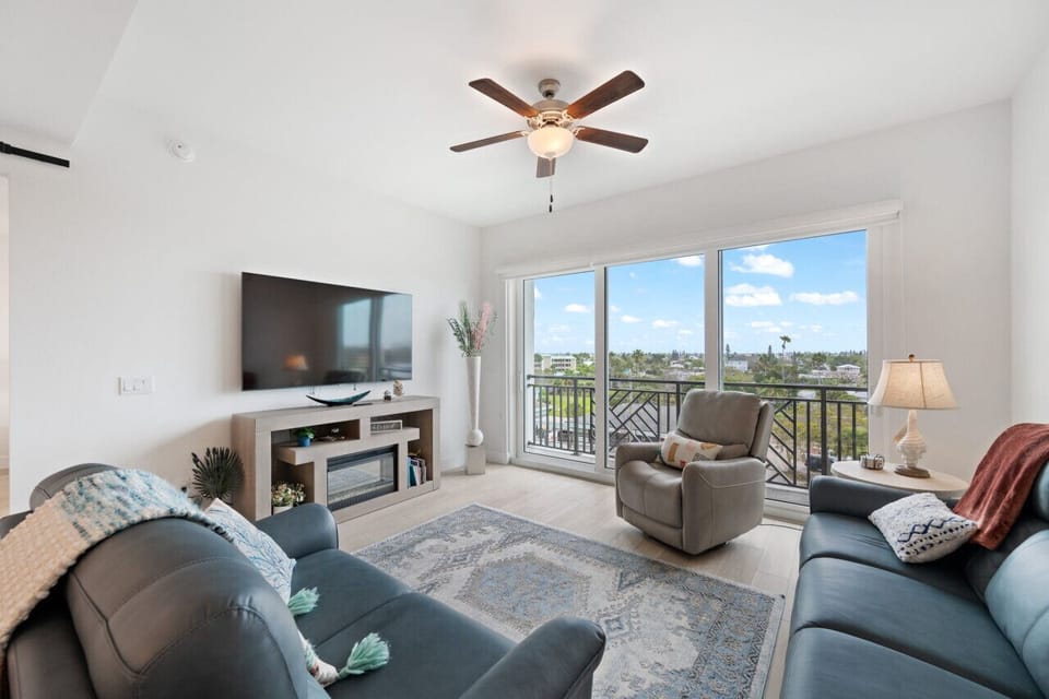 Bright living room w/ comfy seating, TV & sliding doors that open to fresh air & views.