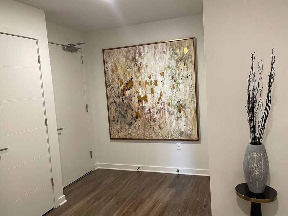 Entryway with the door to where the washer-dryer combo machine is located.