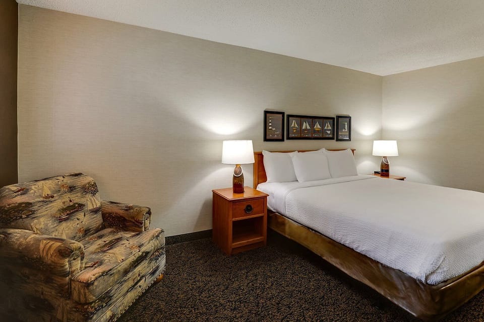 Unwind in a cozy king room with soft bedside lighting.