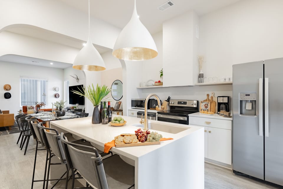 Modern, fully equipped kitchen features an island and stainless steel appliances.