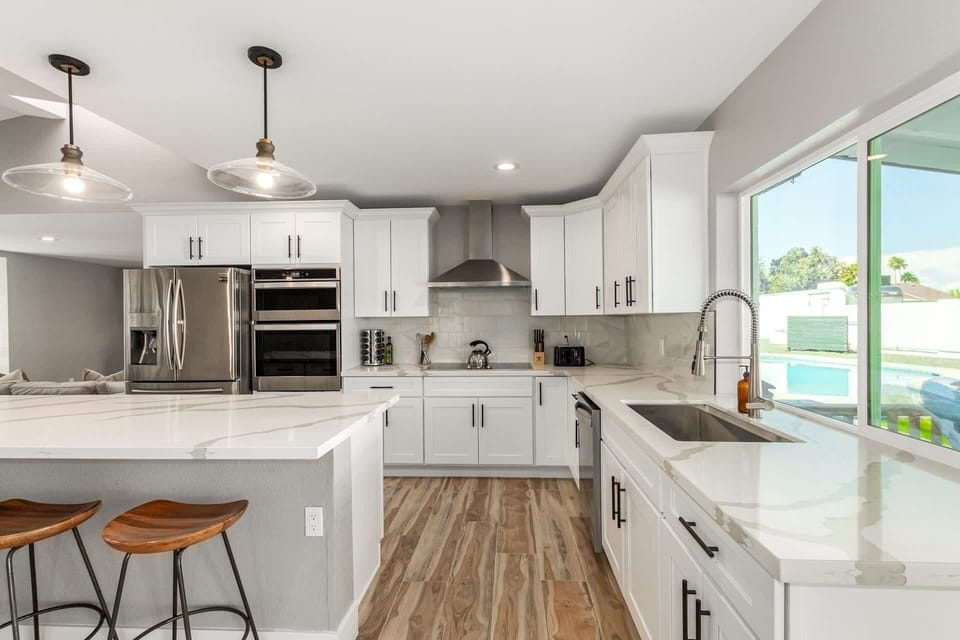 Stainless steel appliances, white cabinets and counter tops