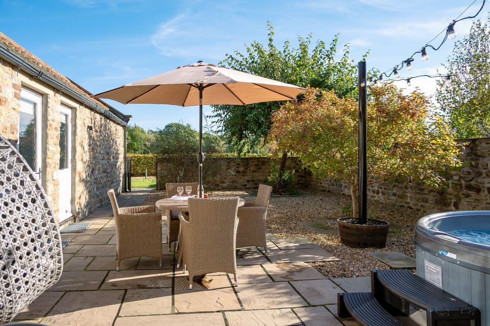 Private hot tub and patio at Austin, a stone-built holiday cottage with outdoor seating in North Yorkshire.