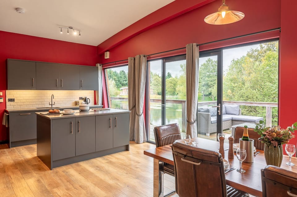 Kitchen and dining area at Isabella with a kitchen island, dining table, and large doors opening onto the deck by the lake.