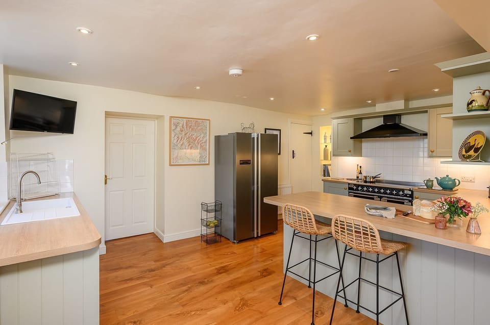 Modern farmhouse kitchen at Hollins Farmhouse holiday home in the Yorkshire Dales with breakfast bar, range cooker and spacious layout.
