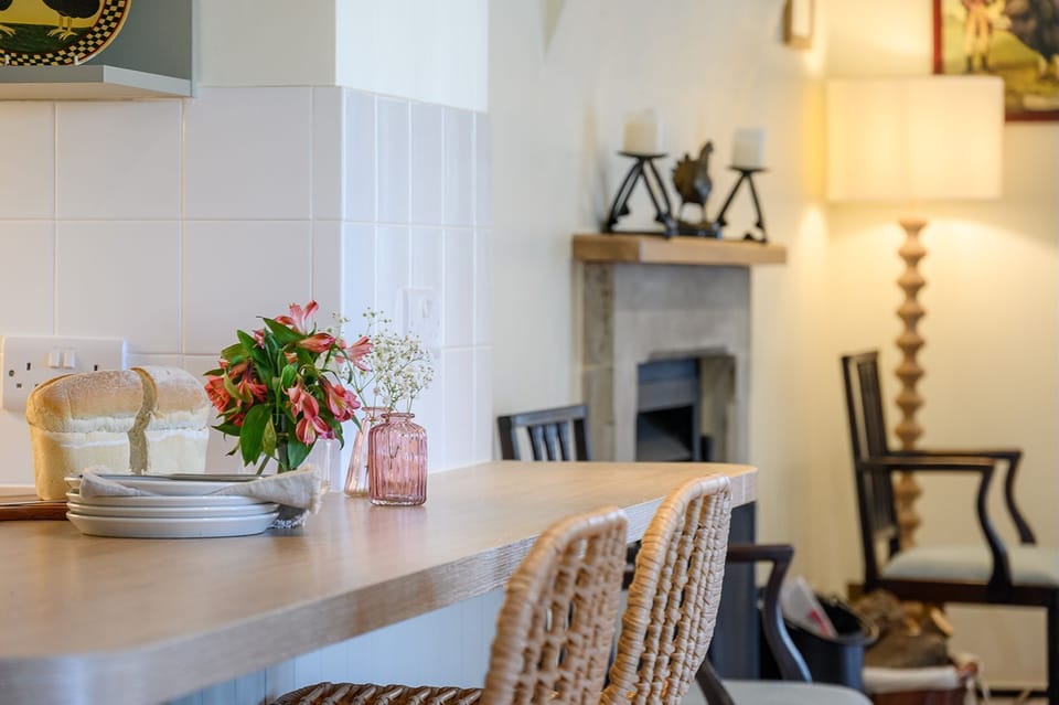 Breakfast bar in the open-plan kitchen at Hollins Farmhouse holiday home in the Yorkshire Dales with cosy living area beyond