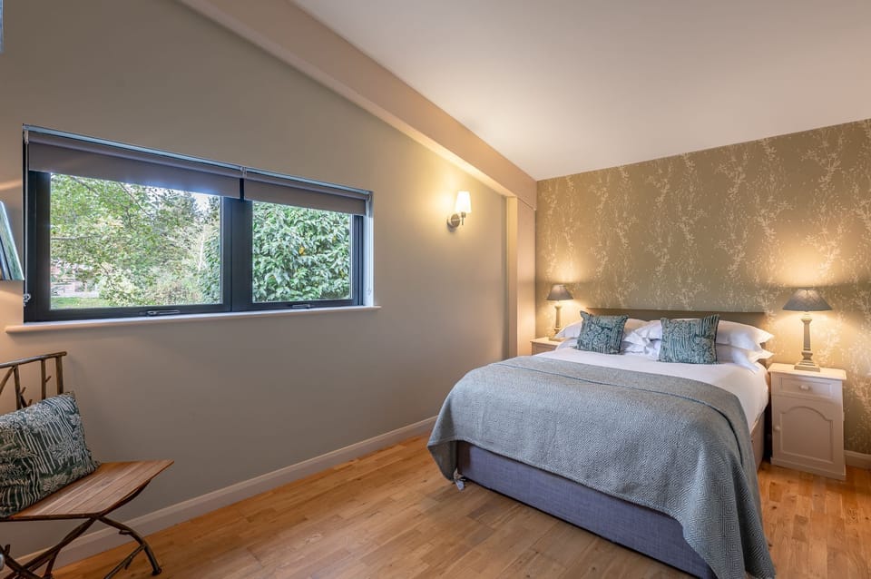 Bedroom in Jasper lodge with king-size bed, armchair and bedside lighting.