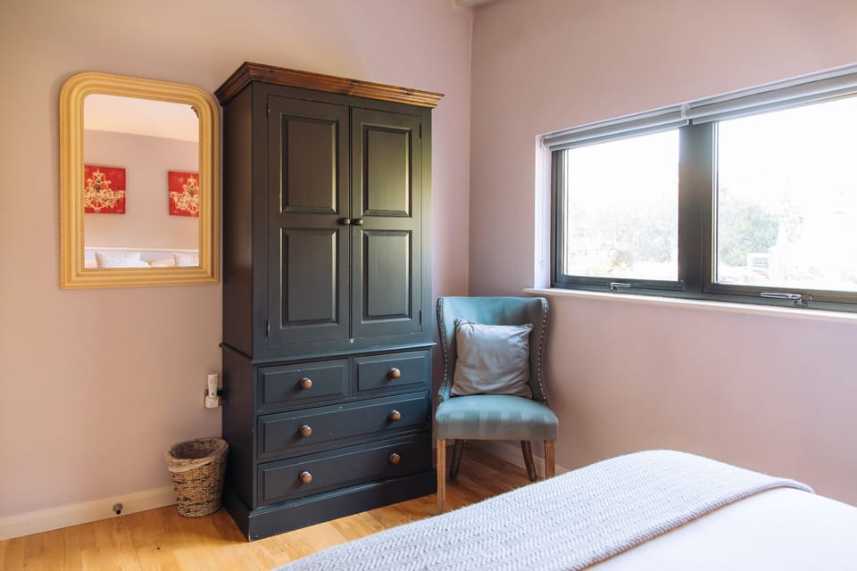 Bedroom with wardrobe and seating area in Finley lodge.