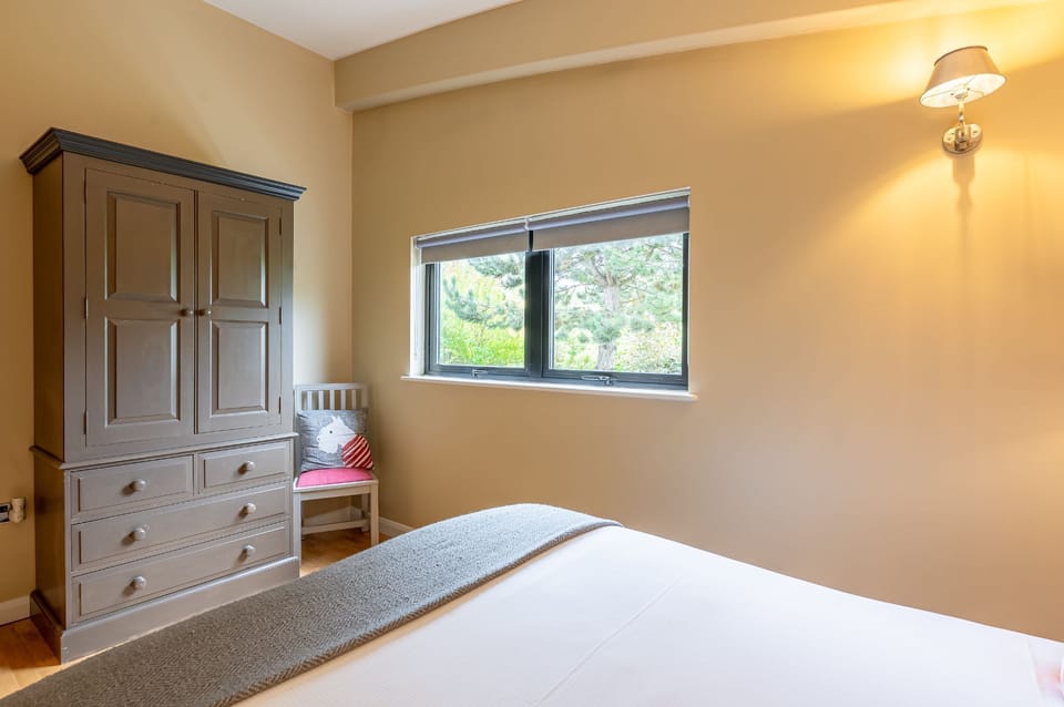 Double bedroom in William lodge at Brompton Lakes with neutral tones, wardrobe and countryside views.