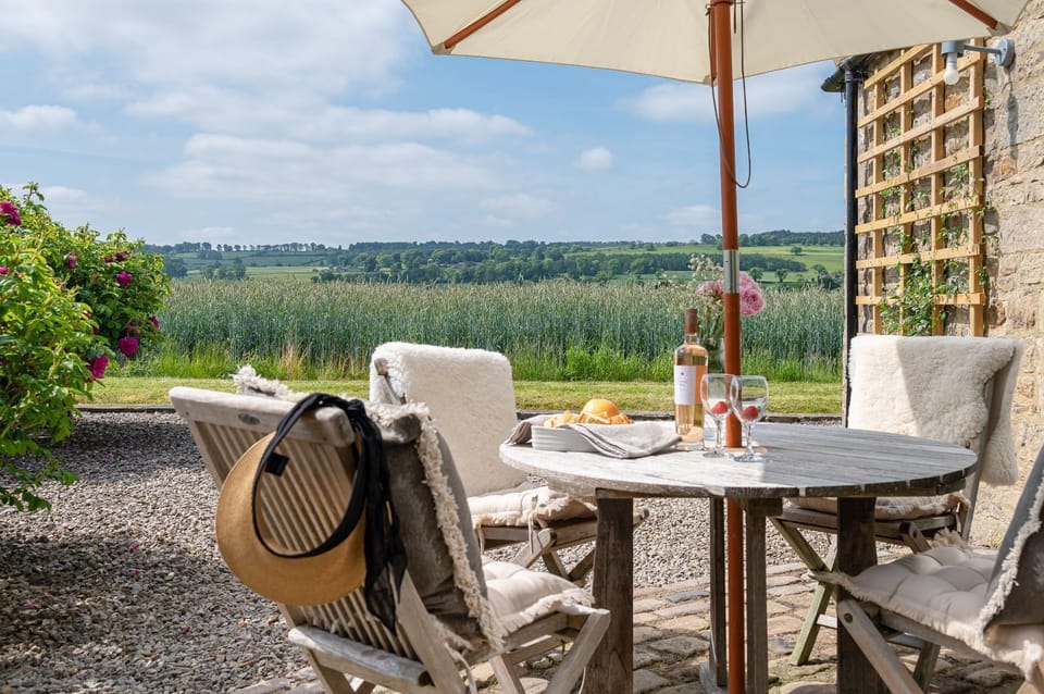Charming patio dining area with countryside views, perfect for al fresco meals and unwinding in peaceful surroundings.