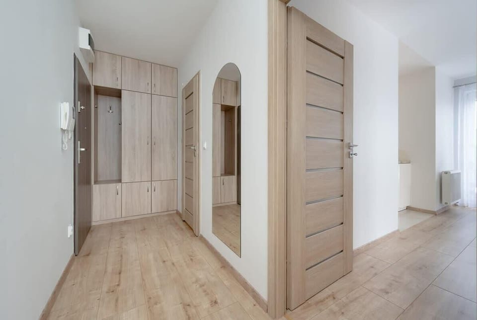Entry hallway with wooden cabinets and a light floor.