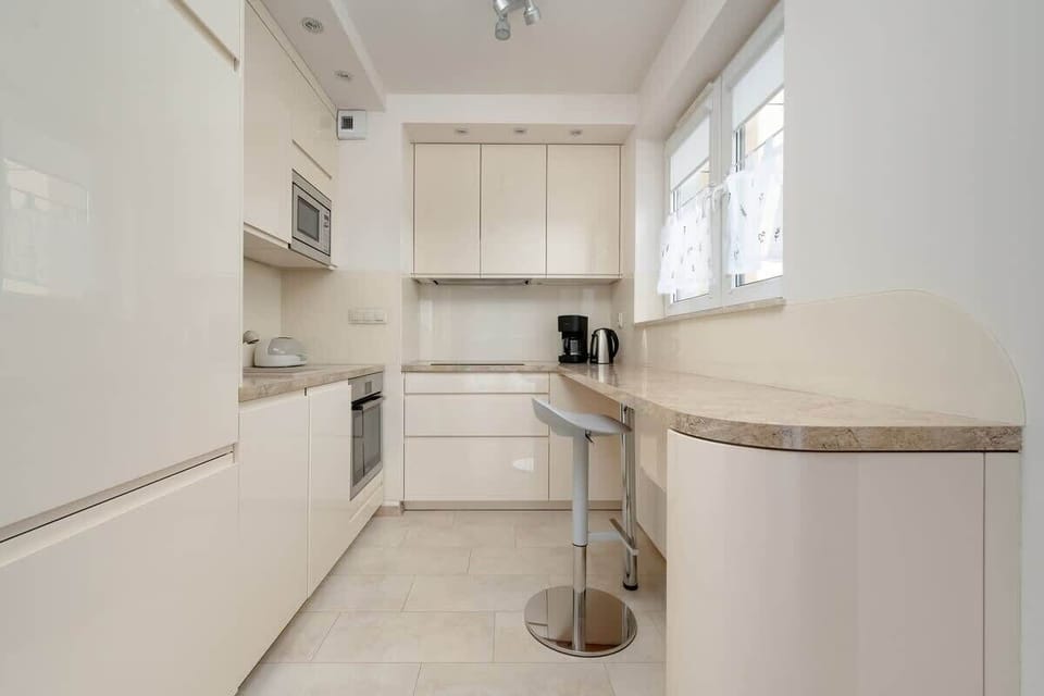 Modern kitchen area with white cabinets and a round counter.