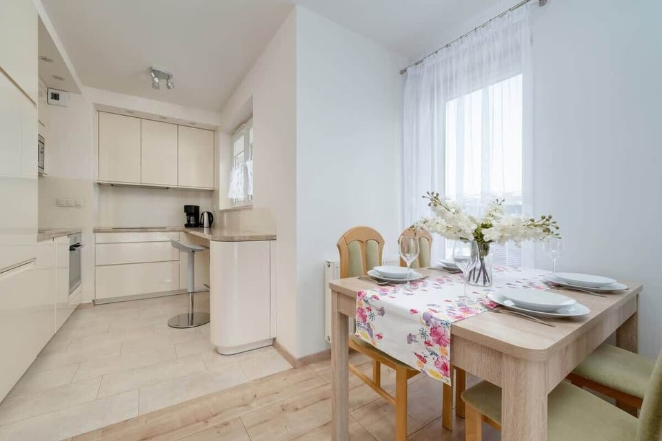 Dining and kitchen area with natural light and a small dining table.