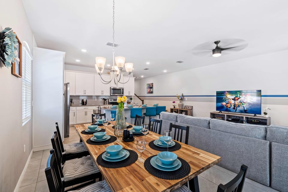 Experience the opulent dining area in Kissimmee, featuring an impressive 8-seater table - Majestically adorned with a chandelier and thoughtfully designed  - The lavish space, illuminated by elegant lighting offers a picturesque setting