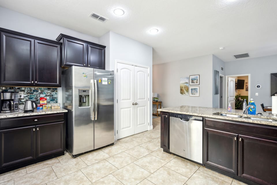 Kitchen is equipped with double sink, dishwasher, and a modern refirgerator
