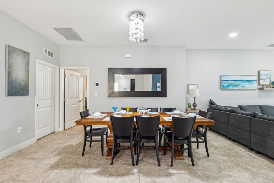 Dining area with 6 seats, chandelier, and a mirror