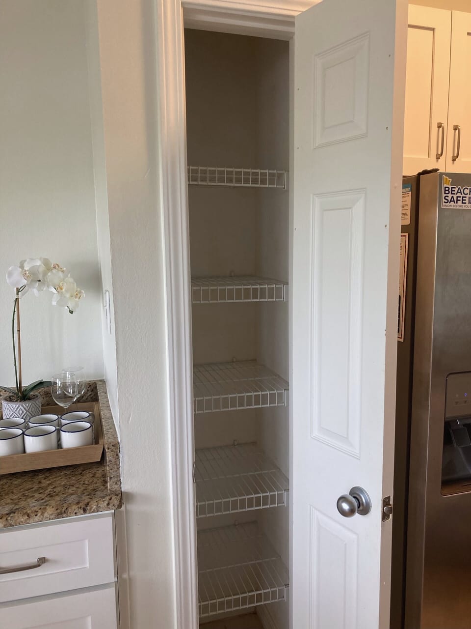 This kitchen features a spacious pantry with wire shelving, perfect for organizing snacks and essentials