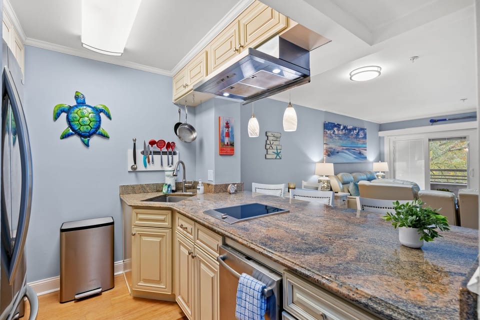 Coastal kitchen with granite peninsula and bright, open living.