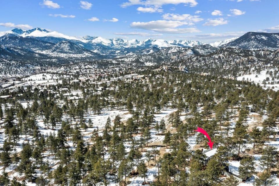 Aerial View of Home and the Rocky Mountains that tower over from the distance