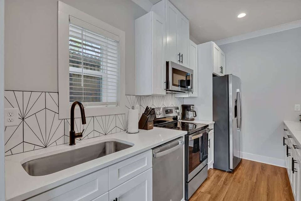Fully equipped kitchen with all culinary essentials boasting stainless-steel appliances, ample counter space and a breakfast table for dining.
