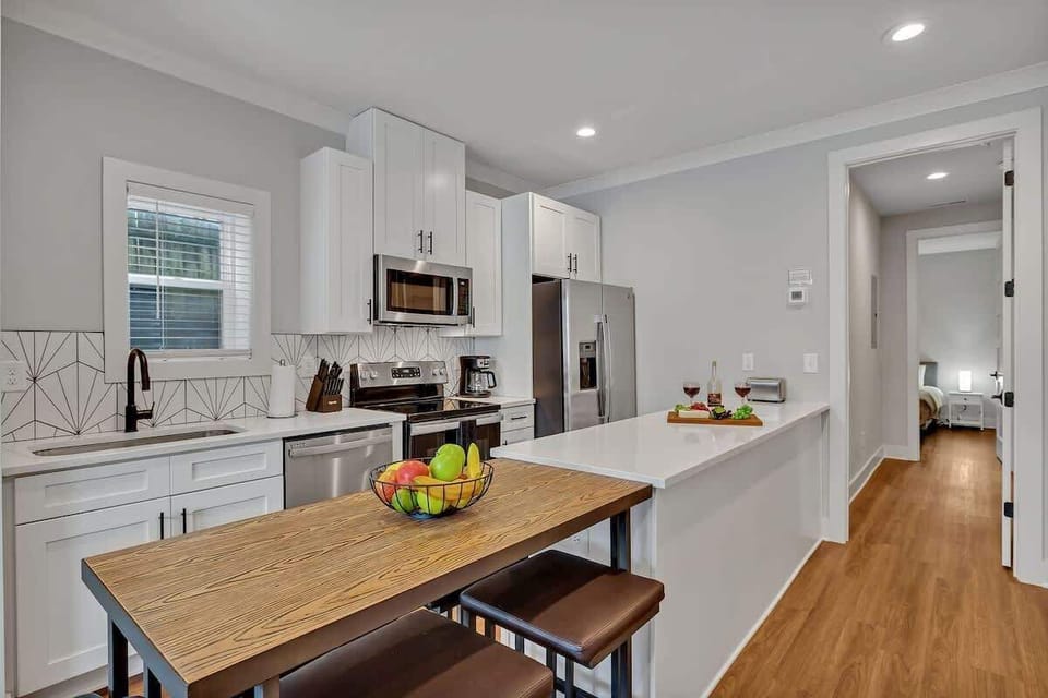 Fully equipped kitchen with all culinary essentials boasting stainless-steel appliances, ample counter space and a breakfast table for dining.
