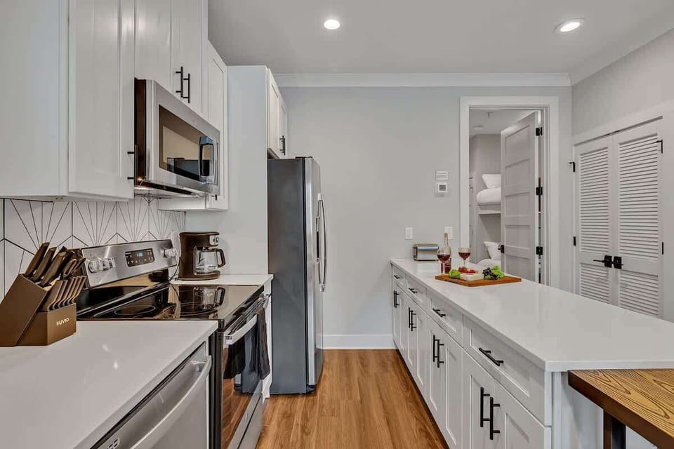 Fully equipped kitchen with all culinary essentials boasting stainless-steel appliances, ample counter space and a breakfast table for dining.