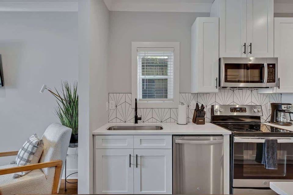 Fully equipped kitchen with all culinary essentials boasting stainless-steel appliances, ample counter space and a breakfast table for dining.