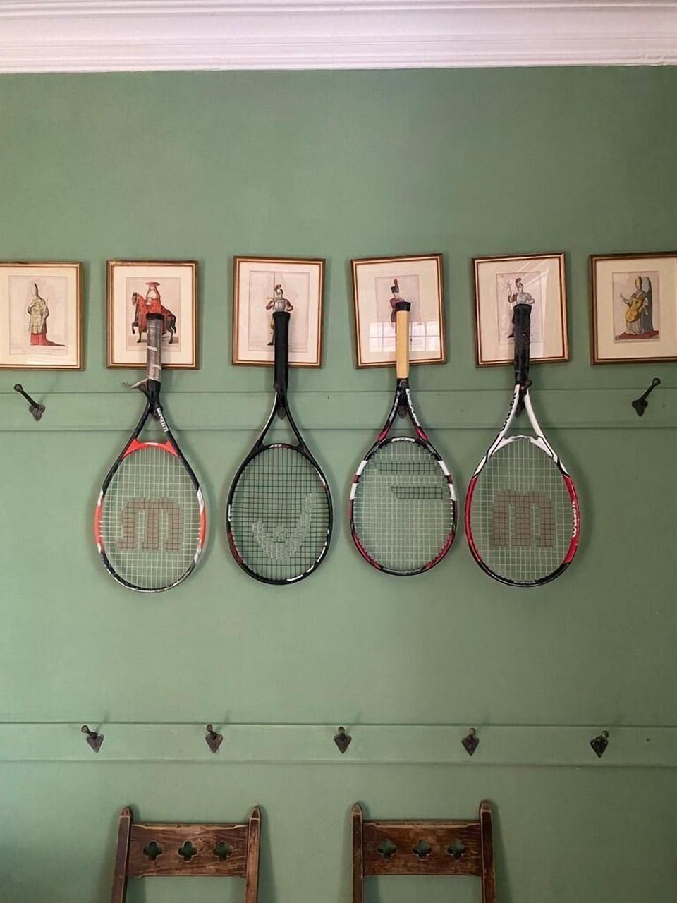 Tennis rackets, portraits, hooks in the green hall