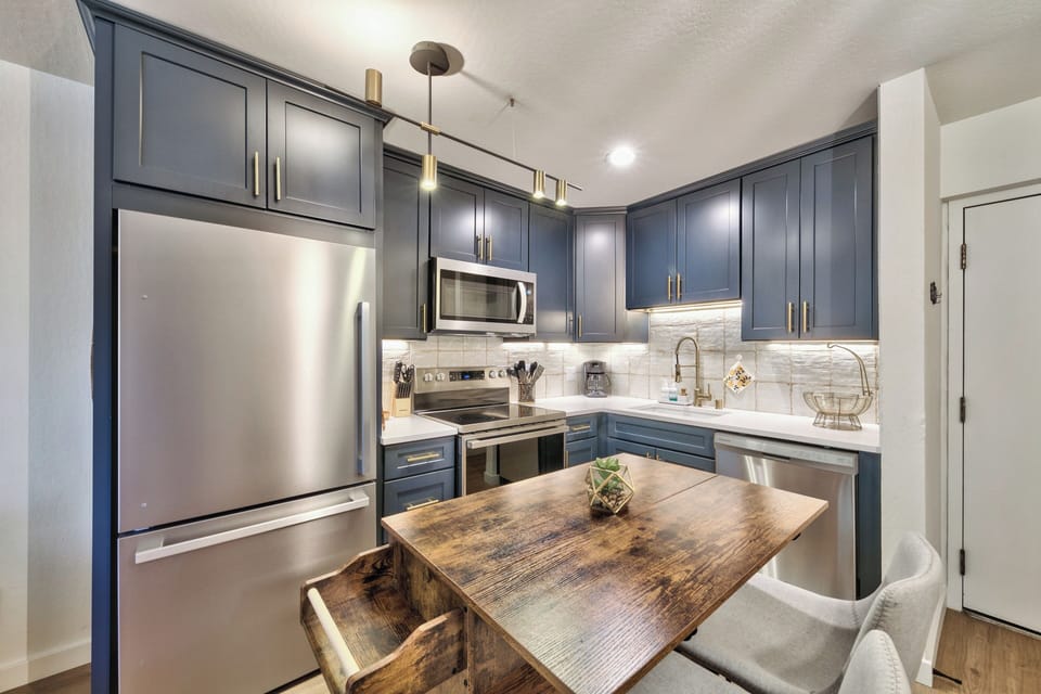 Your gourmet kitchen awaits with navy cabinets, stainless appliances, and a rustic island perfect for morning coffee or evening meals.