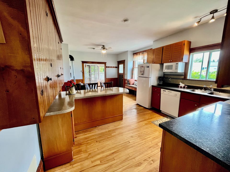 Kitchen with island for seating. Walk through the sliding doors to a sunroom